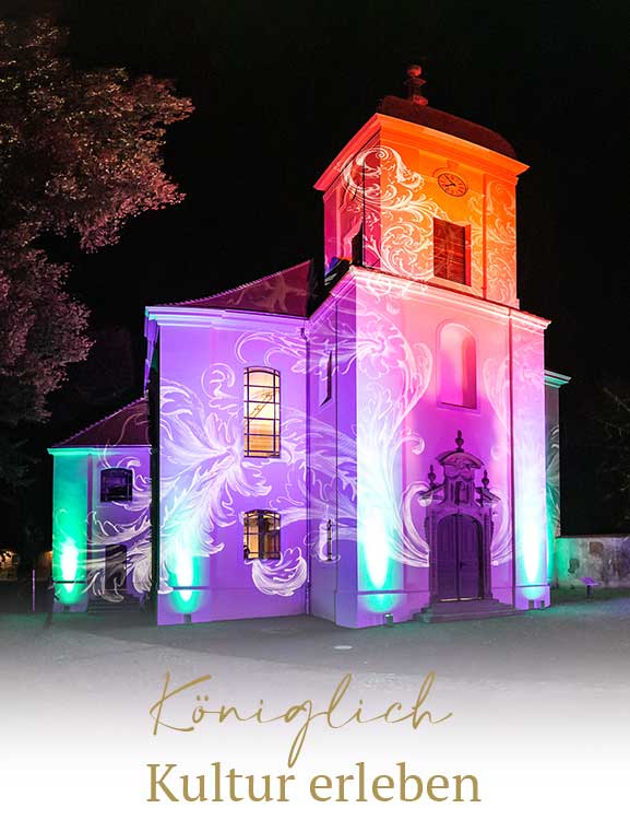 Farbenfroh beleuchtete Schlosskirche bei einem nächtlichen Event im Schlossgut Altlandsberg